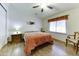 Bright bedroom features a ceiling fan, wood floors, and a cozy armchair at 17200 W Bell Rd # 1551, Surprise, AZ 85374