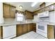 Well-lit kitchen features wood cabinets, white appliances, and a window with valance at 17200 W Bell Rd # 1551, Surprise, AZ 85374