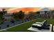 A sprawling backyard with manicured lawn, decorative plants, privacy fence and comfortable lounge chairs set against a sunset sky at 17801 W Mountainair St, Surprise, AZ 85388