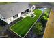 Aerial view of a backyard with a pool, lounge area, and pristine artificial grass, creating a serene outdoor oasis at 17801 W Mountainair St, Surprise, AZ 85388