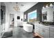 Bright bathroom features a standalone tub, geometric tiling, and a large sunny window at 17801 W Mountainair St, Surprise, AZ 85388