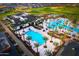 Expansive community pool area with palm trees, lounge chairs, and manicured landscaping, perfect for relaxation at 17801 W Mountainair St, Surprise, AZ 85388