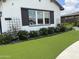 Charming home featuring a manicured front yard with lush artificial grass and flowering bushes at 17801 W Mountainair St, Surprise, AZ 85388