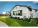 Charming home exterior with manicured lawn, decorative trellis, and inviting curb appeal in a sunny setting at 17801 W Mountainair St, Surprise, AZ 85388