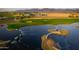 Scenic aerial view of the golf course with a water feature, showcasing lush greenery and beautiful landscaping at 17801 W Mountainair St, Surprise, AZ 85388
