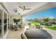 Relaxing outdoor living space with a stone fireplace, plush seating, and serene views of the backyard at 17801 W Mountainair St, Surprise, AZ 85388