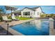 Backyard oasis features a sparkling swimming pool, lounge chairs, and well manicured turf at 17801 W Mountainair St, Surprise, AZ 85388