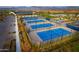 Aerial view of community tennis courts with mountain backdrop, offering residents recreational opportunities at 17801 W Mountainair St, Surprise, AZ 85388