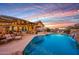 Stunning backyard with a swimming pool, outdoor kitchen, dining area, and lush landscaping at sunset at 18919 W Verde Ln, Litchfield Park, AZ 85340