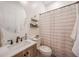 Comfortable half-bathroom with wood-styled vanity, round mirror, and chevron shower curtain at 18919 W Verde Ln, Litchfield Park, AZ 85340