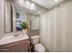 Cozy bathroom featuring a vanity sink, toilet, shower with curtain, and neutral decor at 18919 W Verde Ln, Litchfield Park, AZ 85340