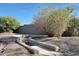 Unique backyard firepit with built-in seating and desert landscaping, perfect for outdoor entertaining at 18919 W Verde Ln, Litchfield Park, AZ 85340