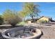 Unique backyard firepit with built-in seating and desert landscaping, perfect for outdoor entertaining at 18919 W Verde Ln, Litchfield Park, AZ 85340