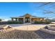 Inviting single-story home featuring a stone accented porch, desert landscaping, and circular driveway at 18919 W Verde Ln, Litchfield Park, AZ 85340