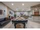 Basement game room with pool table, comfortable seating, and a wet bar at 18919 W Verde Ln, Litchfield Park, AZ 85340