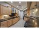 Well-lit kitchen with sleek black appliances, granite countertops, and light wood cabinetry at 18919 W Verde Ln, Litchfield Park, AZ 85340
