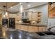 Open kitchen with a large black refrigerator, granite countertops, and light wood cabinets at 18919 W Verde Ln, Litchfield Park, AZ 85340