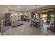 Open-concept living room with tile floors, neutral colors, and modern lighting fixtures at 18919 W Verde Ln, Litchfield Park, AZ 85340