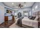 Spacious main bedroom with wood floors, a ceiling fan, and a view into the ensuite bathroom at 18919 W Verde Ln, Litchfield Park, AZ 85340
