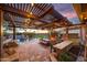 Relaxing outdoor space featuring an outdoor kitchen, dining area, pool, and a cozy fireplace with sunset views at 18919 W Verde Ln, Litchfield Park, AZ 85340