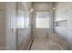 Modern shower with glass enclosure and decorative tiled walls and flooring at 18919 W Verde Ln, Litchfield Park, AZ 85340