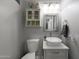 Modern half bathroom featuring a stylish vanity, decorative wall cabinet, and neutral decor at 20709 N 56Th Dr, Glendale, AZ 85308