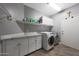 Functional laundry room featuring modern washer and dryer, and ample storage space at 20709 N 56Th Dr, Glendale, AZ 85308