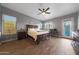 Spacious main bedroom featuring wood floors, a ceiling fan, and a walkout to the backyard pool at 20709 N 56Th Dr, Glendale, AZ 85308