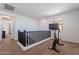 Bright hallway landing area featuring a workout bike, carpet floors, and natural light at 20947 E Mayberry Rd, Queen Creek, AZ 85142