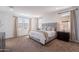 Bright, airy main bedroom with neutral tones, soft carpet, and natural light creates a relaxing atmosphere at 20947 E Mayberry Rd, Queen Creek, AZ 85142