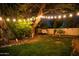 A charming backyard features a swing, green lawn, mature trees, and string lights for delightful outdoor living at 22339 N 77Th Way, Scottsdale, AZ 85255