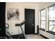 Bright exercise room with a treadmill, black door, artwork, and sunlit windows at 22339 N 77Th Way, Scottsdale, AZ 85255
