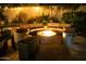 Outdoor firepit lounge area with stone pavers, lush landscaping, and soft lighting, great for entertainment at 22339 N 77Th Way, Scottsdale, AZ 85255