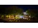Night view of home showcasing mature trees, desert landscaping, and a three-car garage at 22339 N 77Th Way, Scottsdale, AZ 85255