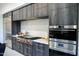 Modern kitchen with stainless steel appliances, gray cabinets, and light marble backsplash at 22339 N 77Th Way, Scottsdale, AZ 85255