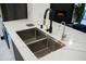 Modern kitchen sink with stainless steel basins, black faucet, and white marble countertops at 22339 N 77Th Way, Scottsdale, AZ 85255