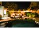 An alluring outdoor pool featuring a central fire pit and ambient string lights for enchanting evening relaxation at 22339 N 77Th Way, Scottsdale, AZ 85255