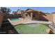 Backyard with a covered patio, a pool, desert landscaping, and a putting green at 22583 W Lasso Ln, Buckeye, AZ 85326