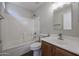 Bathroom featuring a shower-tub combo, wood vanity, a framed mirror and modern sink at 22583 W Lasso Ln, Buckeye, AZ 85326