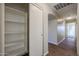 Hallway with wood-look floors, open shelving, closet, and arched doorways to other rooms at 22583 W Lasso Ln, Buckeye, AZ 85326