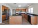 Bright kitchen with stainless steel appliances, wood cabinets, black counters, and a center island at 22583 W Lasso Ln, Buckeye, AZ 85326