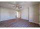 Open living room featuring wood-look floors, a ceiling fan, neutral paint, and an arched doorway at 22583 W Lasso Ln, Buckeye, AZ 85326