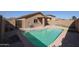Backyard featuring a pool, desert landscaping, a putting green, and a covered patio at 22583 W Lasso Ln, Buckeye, AZ 85326