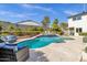 Beautiful backyard pool with lush landscaping, cozy lounge seating, and a perfect area for relaxing outdoors at 2276 E Mercer Ln, Phoenix, AZ 85028