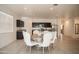 Bright dining area with a table set for six adjacent to a kitchen with stainless steel appliances at 25615 W Allen St, Buckeye, AZ 85326