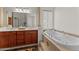 Bright bathroom with double vanity, soaking tub, and decorative pillar at 2855 N Silver Spur Dr, Wickenburg, AZ 85390