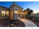 Close up of the home's entry featuring lit columns and mature desert landscaping at 2855 N Silver Spur Dr, Wickenburg, AZ 85390