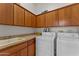 Functional laundry room with ample cabinet space, a sink, and modern washer and dryer at 2855 N Silver Spur Dr, Wickenburg, AZ 85390