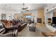 Spacious living room with leather furniture, a cozy fireplace, and desert views at 2855 N Silver Spur Dr, Wickenburg, AZ 85390