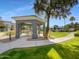 Exterior shot of a community gazebo with a stone table surrounded by green grass and palm trees at 295 N Rural Rd # 128, Chandler, AZ 85226